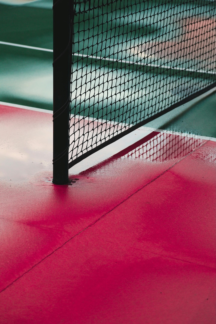 Rain-soaked pickleball court with net